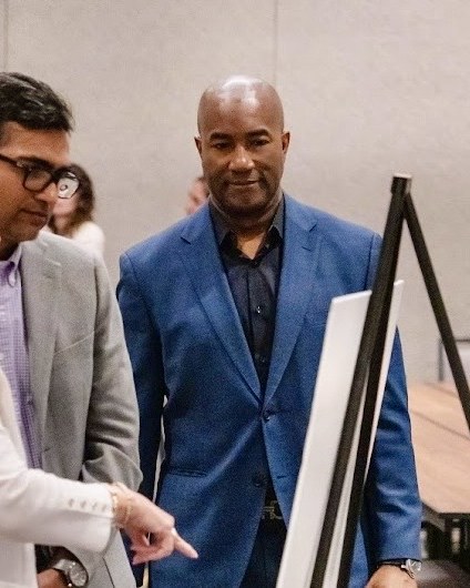 Jason Cummings reviewing strategy at an easel with collaborators